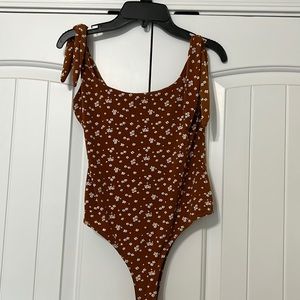 Rust colored body suit with flower pattern